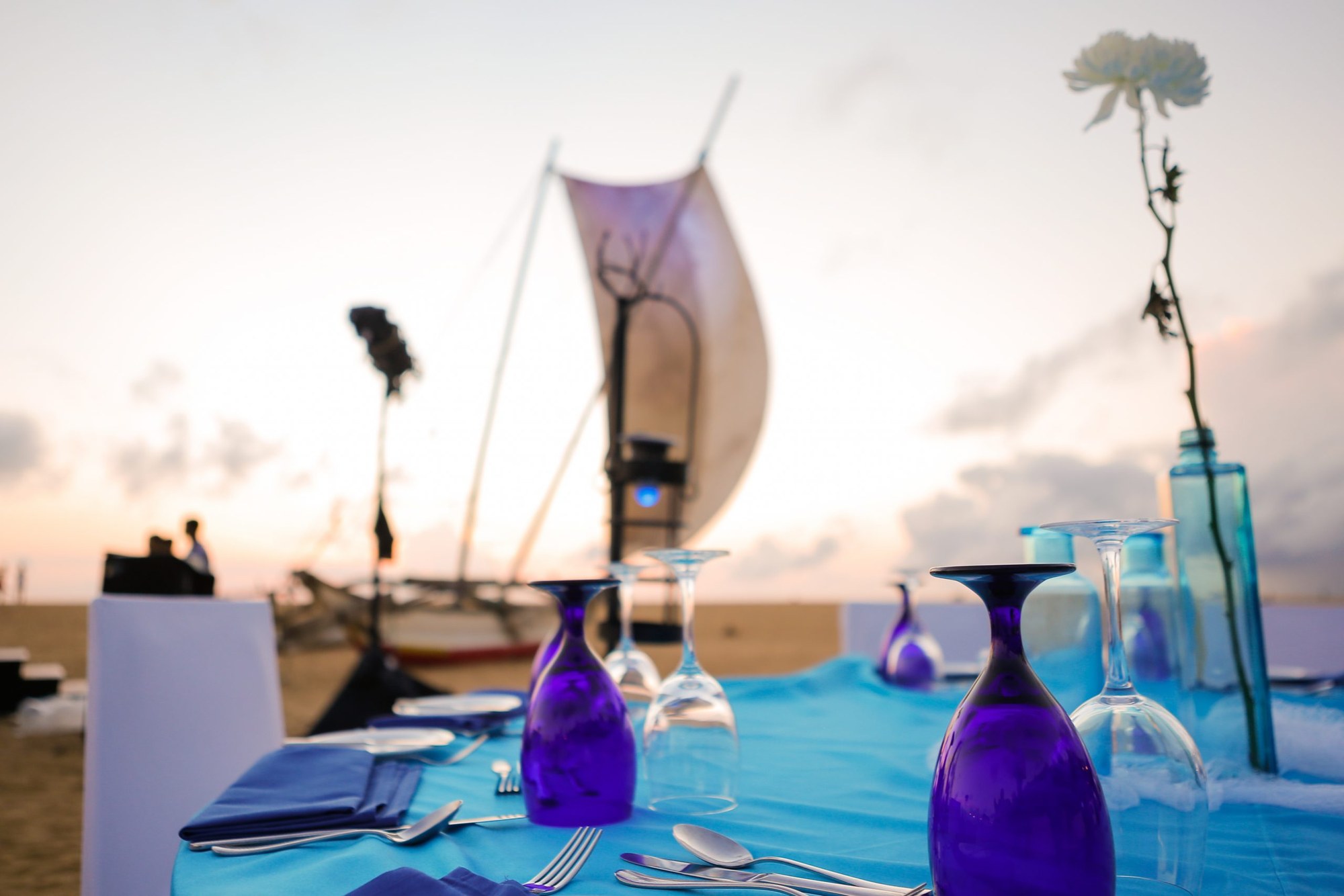 Sunset reception table setting with blue glassware
