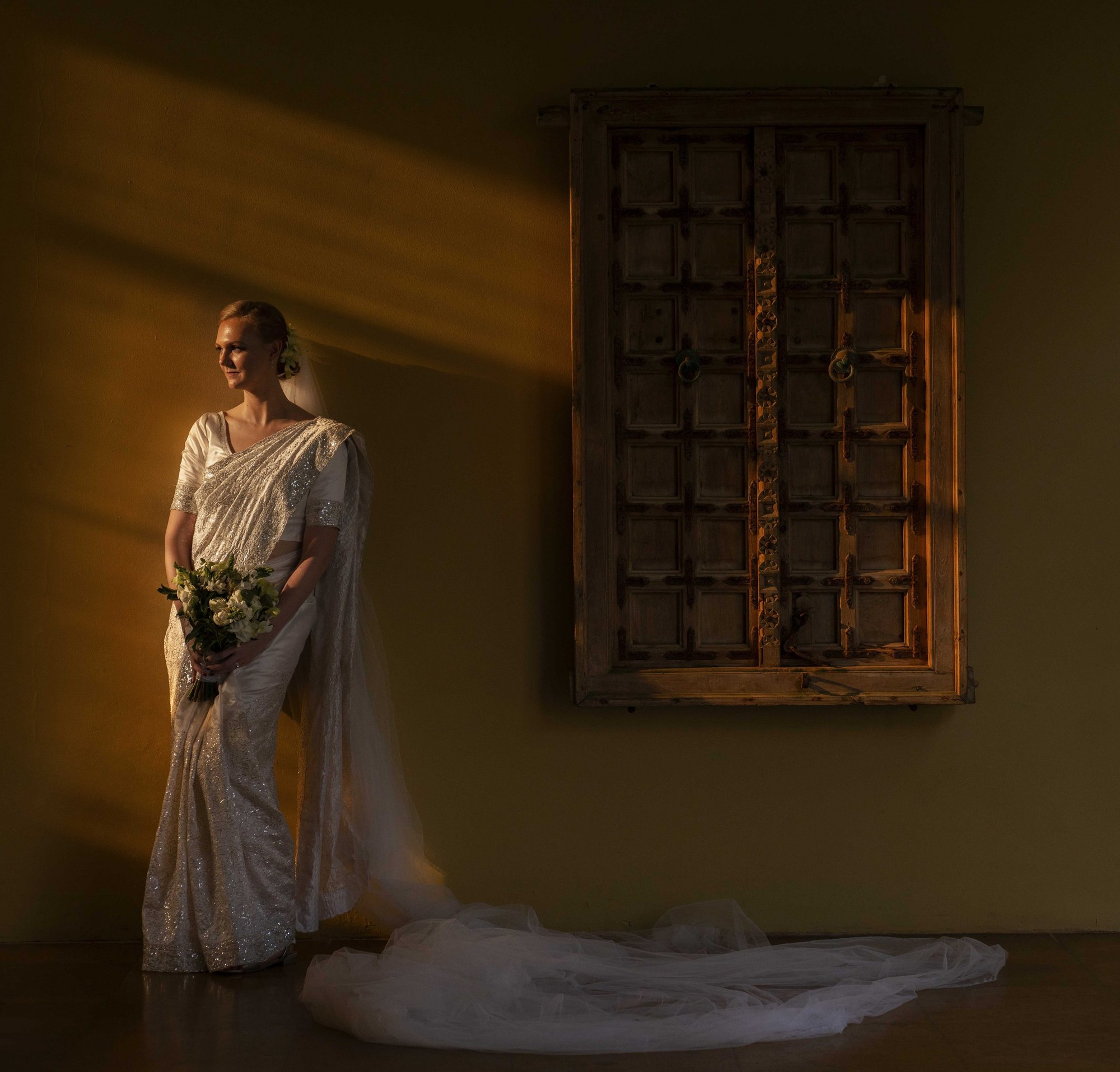 Bride with a long veil in golden sunlight